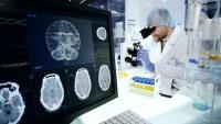 scientist with microscope. Brainwave scanning research on computer screen